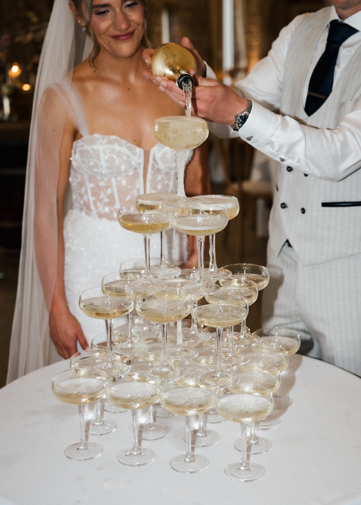 Couple pouring champagne into a champagne tower